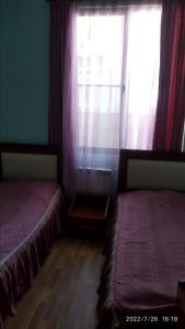 2 letti posti in una stanza con finestra di Nairi a Sevan