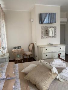 - une chambre avec un lit, une commode et un miroir dans l'établissement Casa Vacanze la Pineta, à Montalcino