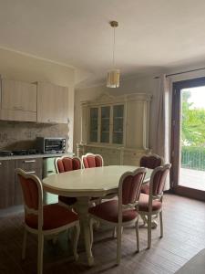 une cuisine avec une table, des chaises et une table. dans l'établissement Casa Vacanze la Pineta, à Montalcino