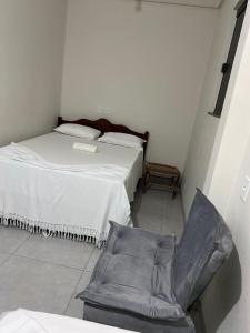ein Schlafzimmer mit einem Bett und einem Stuhl darin in der Unterkunft HOTEL E RESTAURANTE LIMA in Luis Eduardo Magalhaes