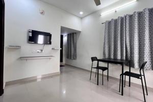 comedor con mesa negra y sillas en Bigson Service Apartments Gachibowli, en Hyderabad