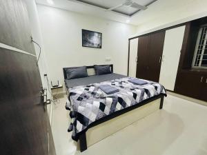 a bedroom with a bed with a black and white comforter at Bigson Service Apartments Gachibowli in Hyderabad