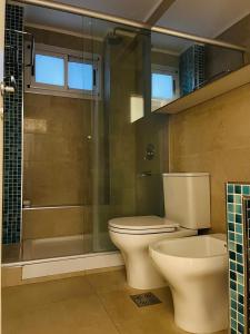a bathroom with a toilet and a glass shower at Departamento céntrico 2 dormitorios in San Nicolás de los Arroyos