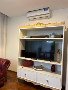 a white entertainment center with a flat screen tv at Departamento céntrico 2 dormitorios in San Nicolás de los Arroyos