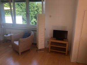 ein Wohnzimmer mit einem Stuhl und einem TV in der Unterkunft Glück in Benrath in Düsseldorf