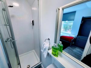 a bathroom with a shower and a sink and a mirror at Berridge Solo Stays - NG7 in Nottingham