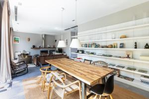uma cozinha e sala de jantar com uma mesa de madeira e cadeiras em Villa Pedregalejo near the beach em Málaga