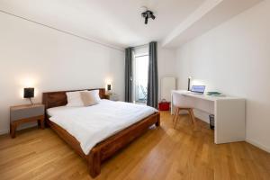 um quarto com uma cama e uma secretária com um computador portátil em Brera Serviced Apartments Nürnberg em Nurembergue