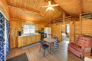 a kitchen and living room in a log cabin at Cozy Farm Cabin - 9 Mi to Trout Creek! in Trout Creek
