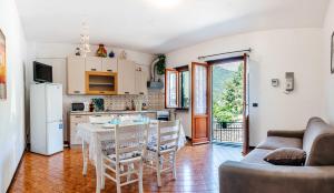 een keuken en een woonkamer met een tafel en stoelen bij Turri House--- WiFi -Garden-Parking -Balcony in Recco