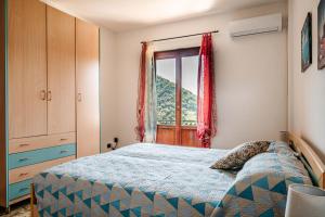 een slaapkamer met een bed en een raam bij Turri House--- WiFi -Garden-Parking -Balcony in Recco