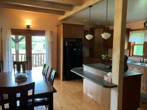 a kitchen with a table and a black refrigerator at Cozy Oaks Cabin 