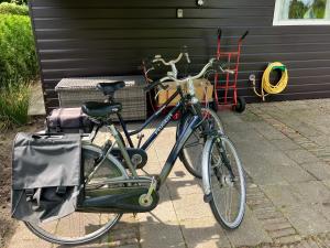 a bike parked next to a building with a basket at Oasis Giethoorn in Giethoorn