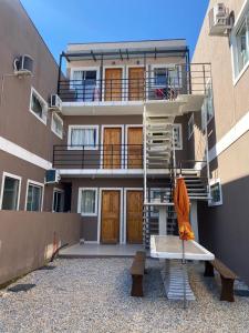 ein Gebäude mit einer Treppe und einer Bank davor in der Unterkunft Residencial da Cris in Florianópolis