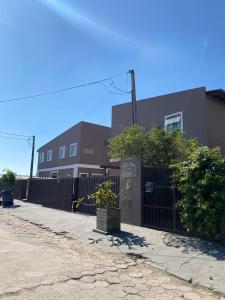 a fence in front of a building with trees at Residencial da Cris in Florianópolis
