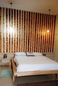 a bedroom with a bed and a wooden wall at Lajungle Muyenga in Kampala