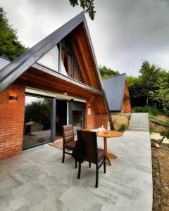 un patio con mesa de madera y sillas en Dawn Villas, en Ferizaj