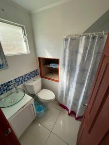 a bathroom with a toilet and a shower curtain at Casa de dos pisos a pasos de la playa in Bahia Inglesa