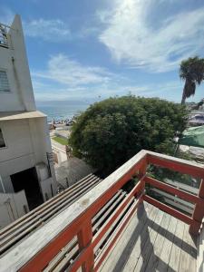 einen Balkon mit einer Holzbank auf einem Gebäude in der Unterkunft Casa de dos pisos a pasos de la playa in Bahia Inglesa