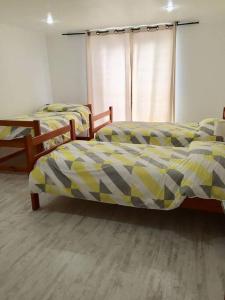 two beds sitting in a room with at Casa de dos pisos a pasos de la playa in Bahia Inglesa