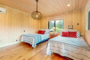 2 Betten in einem Zimmer mit Holzwänden und Holzböden in der Unterkunft Lefty's in Bentonville