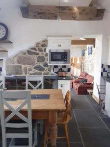 a kitchen with a table and a living room at The Stables in St Ives in St Ives