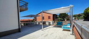 a deck with two chairs and an umbrella at Case Gioto e Bellavista in Passignano sul Trasimeno