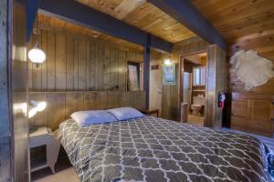 a bedroom with a bed in a room with wooden walls at 2 bedroom and Loft, 2 bath, sleeps 6 Donner Lakefront with private dock DLR#013 in Truckee