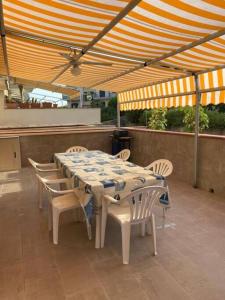 einen Tisch und Stühle unter einem Sonnenschirm auf einer Terrasse in der Unterkunft Casa Vacanza Giardini Naxos Taormina MIRANAXOS in Giardini-Naxos