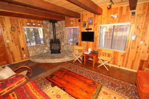 a living room with a stone fireplace in a cabin at 2 bedroom, 2 bath, sleeps 6 adults West End of Donner Lake DLR#021 in Truckee