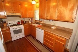 a kitchen with wooden cabinets and a white stove top oven at 2 bedroom, 2 bath, sleeps 6 adults West End of Donner Lake DLR#021 in Truckee