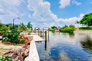 a river with a bridge and trees and clouds in the sky at Rock N' Reel Boat House in Saint James City