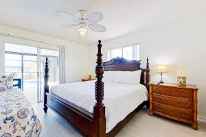 a bedroom with a bed and a dresser and a window at Rock N' Reel Boat House in Saint James City +18 photos