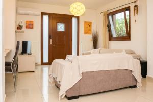 1 dormitorio con 1 cama y TV. en lila's city house, en Rodas