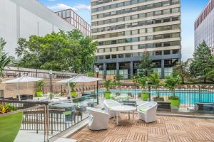 a rooftop patio with tables and chairs and a pool at Style & Fantastic Apartment in Crystal City! in Arlington