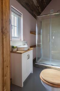 uma casa de banho com um lavatório e um chuveiro em Lake View Lodges em Long Melford