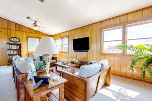 a living room with wood paneling and a tv at Salty Paws in Frisco