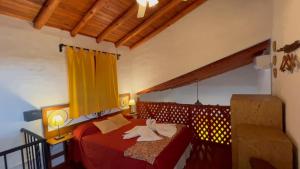 um quarto com 2 camas com lençóis vermelhos e cortinas amarelas em Complejo Sol Serrano em Mina Clavero