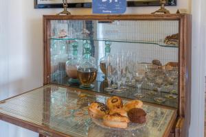 a glass display case with various pastries and wine glasses at Larala' in Lecce