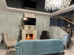 a living room with a couch and a fireplace at Orophile guest house in Gorists'ikhe
