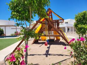 a playground with a slide in a yard at Coral de Cortez - New Beach House in San Carlos