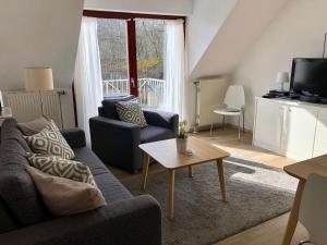 sala de estar con sofá y mesa en Ferienwohnung-Nils-Holgerson-mit-Balkon-zwischen-Strand-Wald-Wiese-im-Suedosten-der-Insel-Ruegen, en Gustow