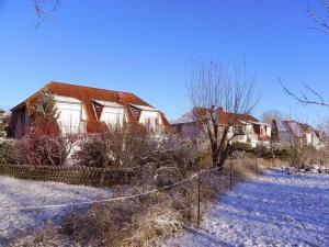 una casa con una valla en la nieve en Ferienwohnung-Nils-Holgerson-mit-Balkon-zwischen-Strand-Wald-Wiese-im-Suedosten-der-Insel-Ruegen, en Gustow