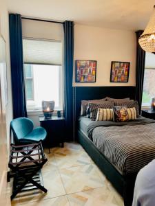 um quarto com uma cama, uma cadeira e uma janela em Moose Manor Guest Suite - Houston em Houston