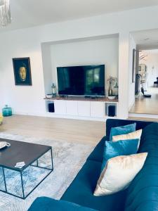 sala de estar con sofá azul y TV en Moose Manor Guest Suite - Houston en Houston