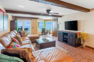 a living room with a couch and a tv at Solana Shoreside Haven in Solana Beach