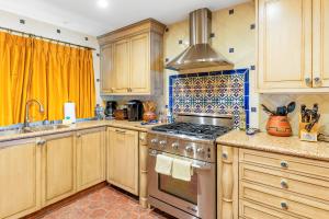 a kitchen with wooden cabinets and a stove top oven at Solana Shoreside Haven in Solana Beach