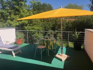 杜塞尔多夫Glück in Benrath的天井配有桌子和黄色雨伞