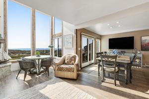 sala de estar con mesa, sillas y TV en Monterey Dune Haven, en Moss Landing