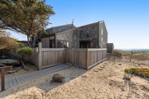 una casa en la playa con una valla de madera en Monterey Dune Haven, en Moss Landing